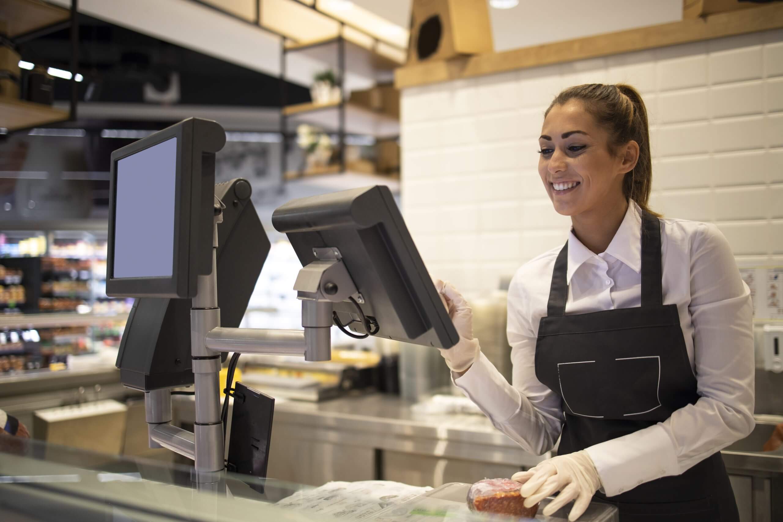 Supermarket worker measuring and selling meat to the customer